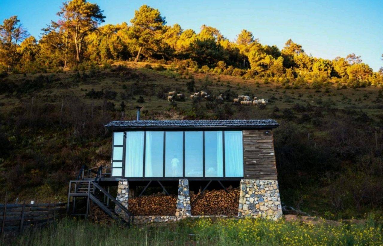 木石结构的玻璃小屋与柴火堆